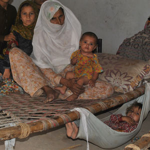 Ali Bagh Jana sits with her grandchildren in her home in Bara Chashmai, Pakistan, on a hot day in July 2024. Credit: Saba Rehman