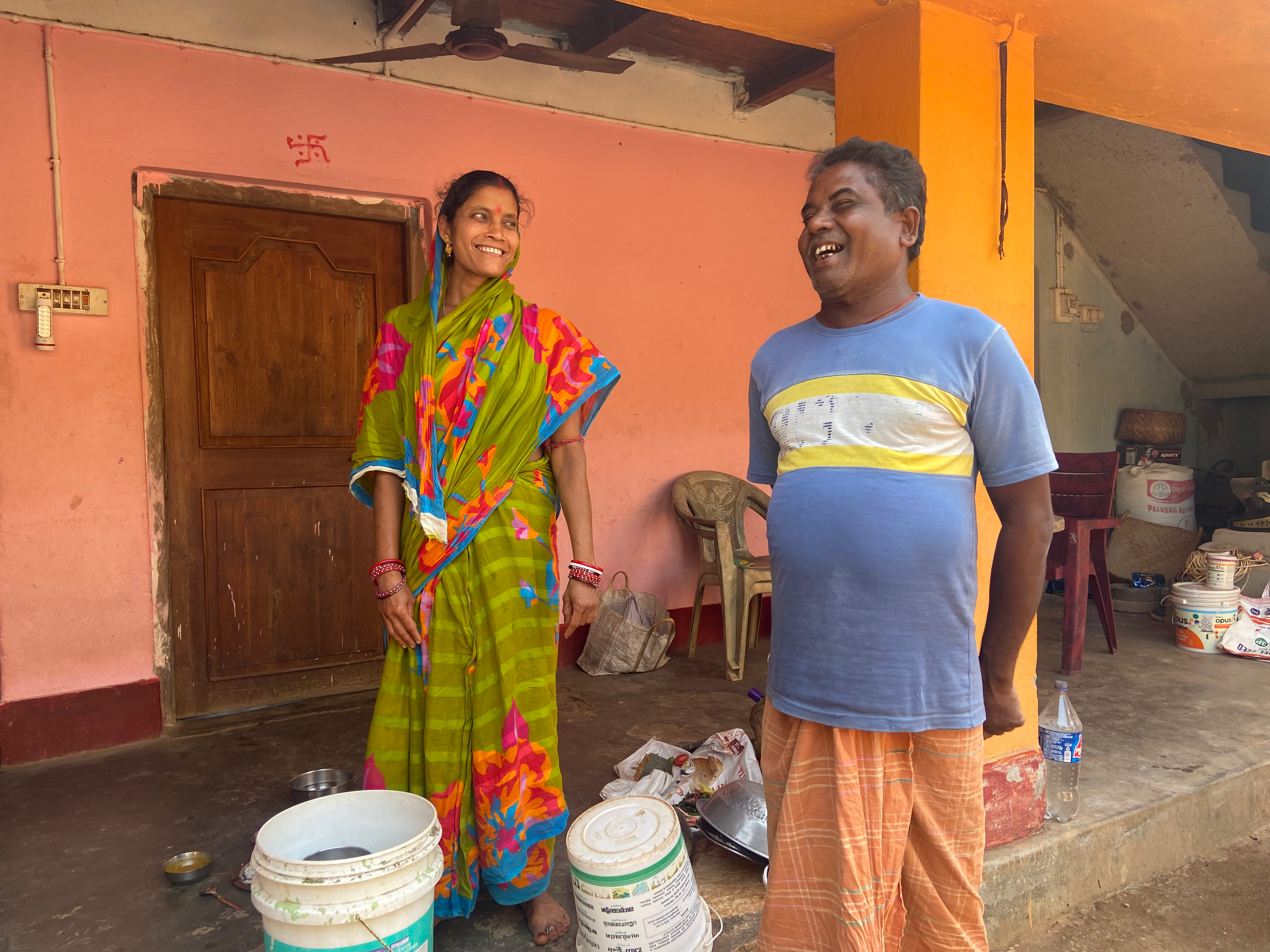 Saudamini and Madan Pradhan stand in front of their home in the village of Bhagatpur, in India’s Odisha state, on February 28, 2025. Roli Srivastava/The Migration Story 
