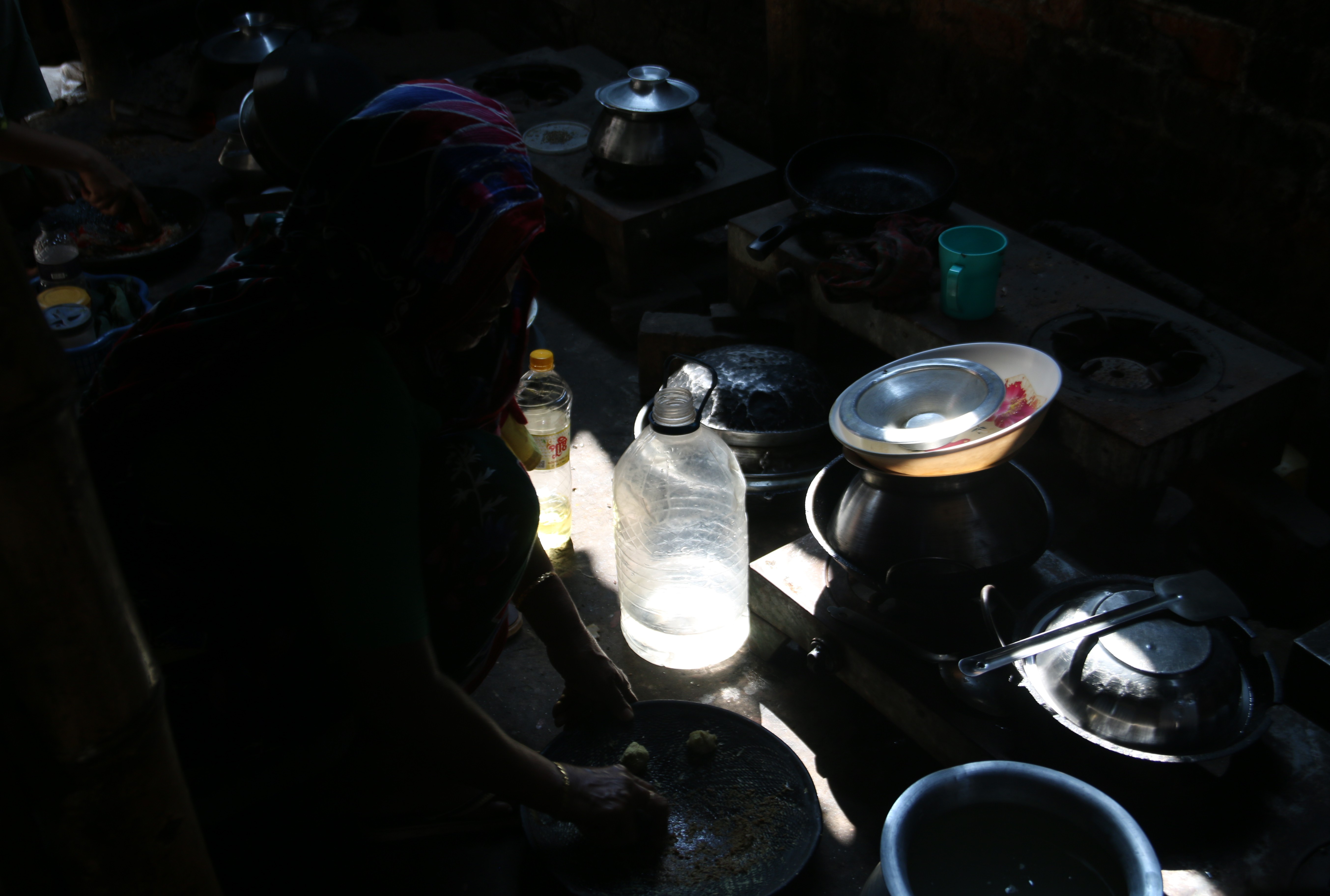 With no electricity, Hazra Begum prepares food for her family amid a heatwave in DuariPara, an area of Dhaka, Bangladesh, on October 15, 2025. A lack of ventilation in her cooking area leaves her drained but she needs to keep her family fed. Climate Resilience for All/Tanvir Ahmed