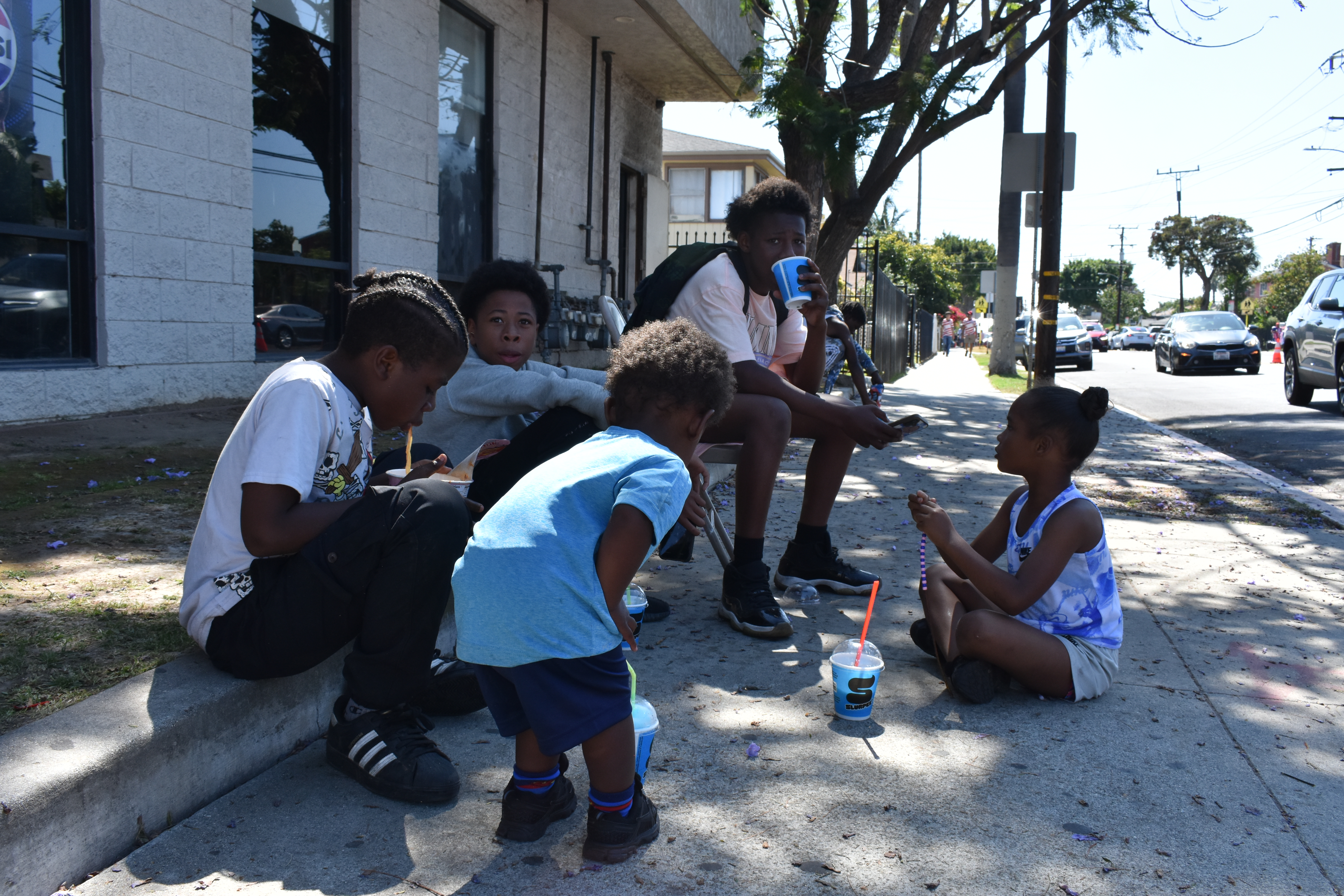 Street vendor Shay’Prea Moore's children, nieces and nephews sit in the shade of a tree while she sells drinks outside L.A.’s first World Cup match, June 12, 2026. HERA/Rachel Parsons